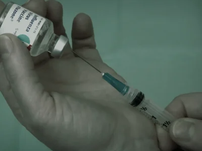 Peptide vial and insulin syringe on a white surface